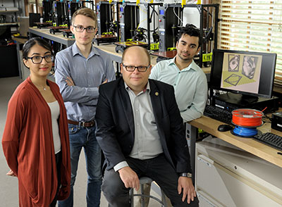 Professor Wawrzyniec Dobrucki (second from right) is joined by PhantomCOR team members Hiba Shahid, Pierce Hadley, and Craig Soares in the 3D printing lab.