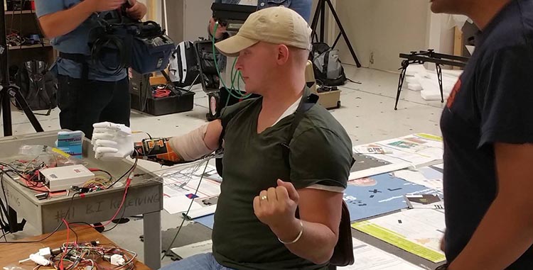 Retired Sergeant Garrett Anderson, who lost his right arm in Iraq in 2005 when a roadside bomb detonated under the truck he was driving, tests a prototype of the prosthesic arm with Aadeel Akhtar, an M.D./Ph.D. student in Beckman's Artificial Intelligence Group.