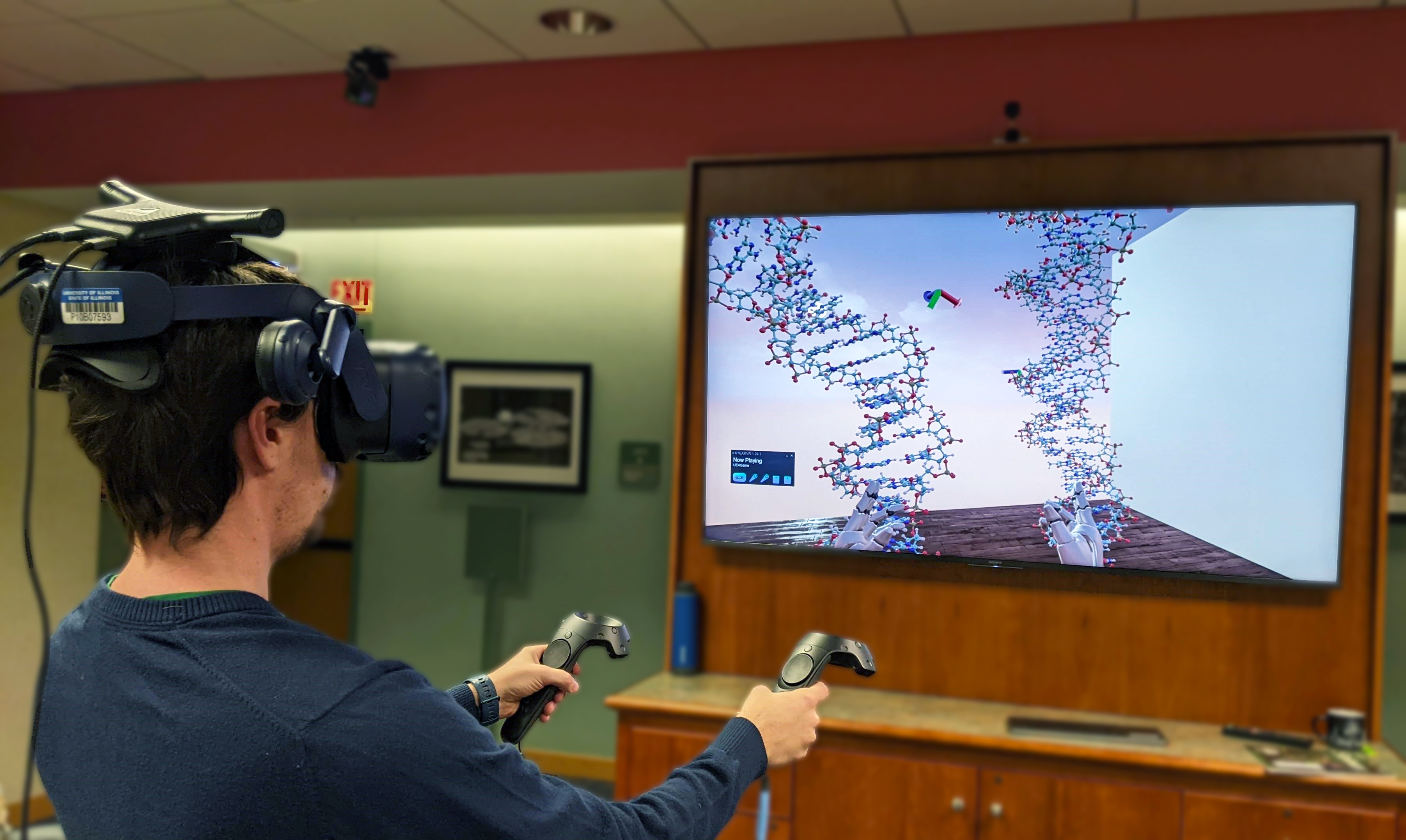 A man operates a virtual reality simulator to manipulate DNA. 