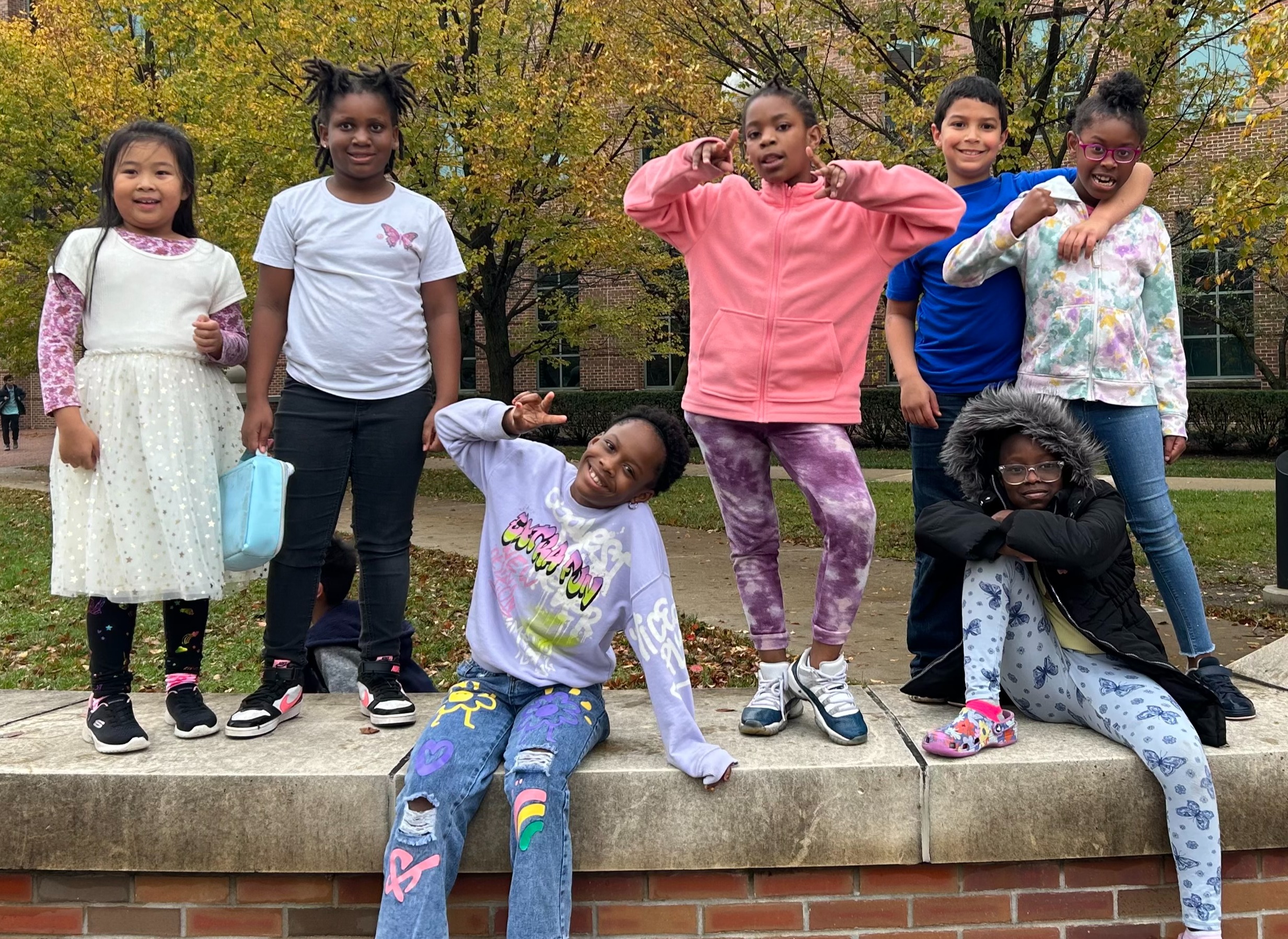 South Side Elementary students pose on a brick wall outside of the Beckman Institute.