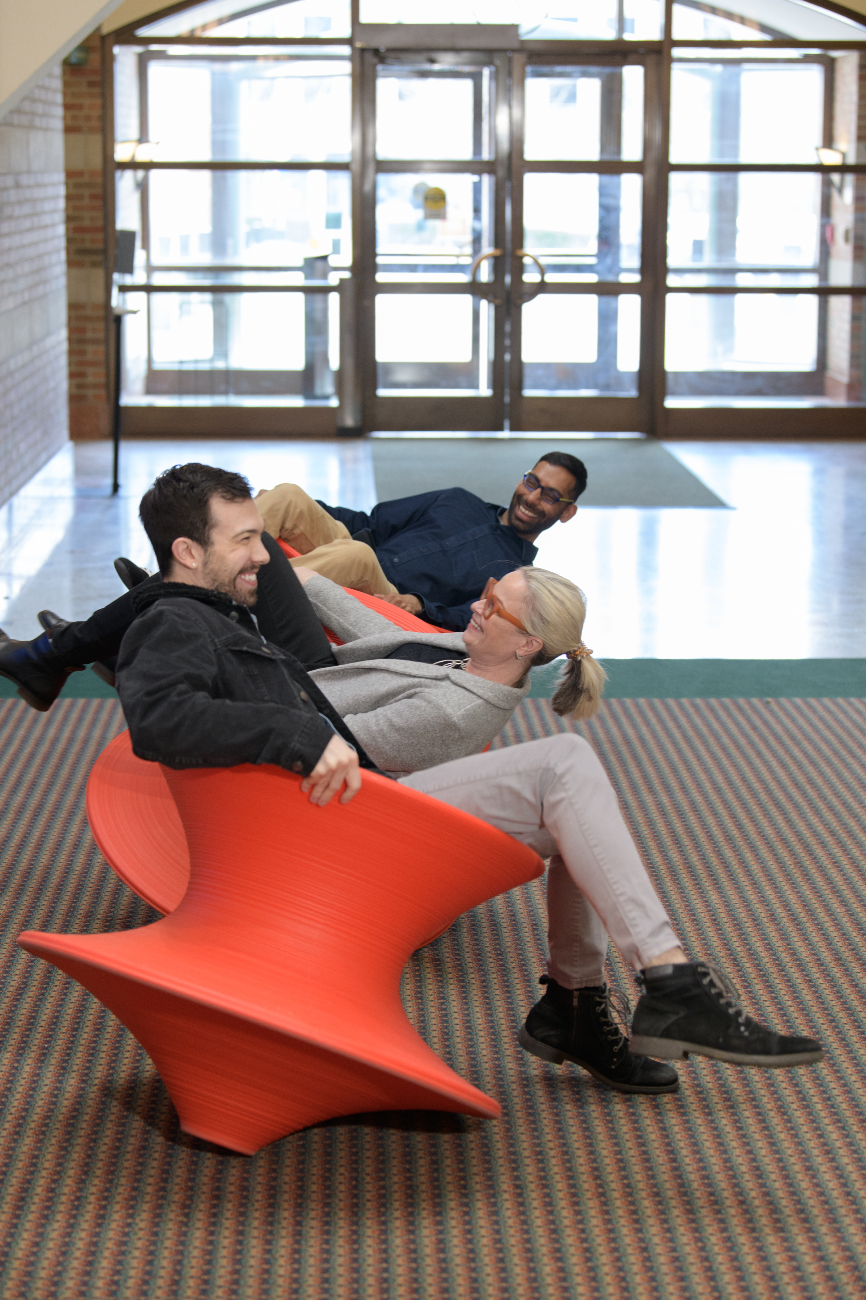 A group enjoys the spun chairs in the Beckman atrium