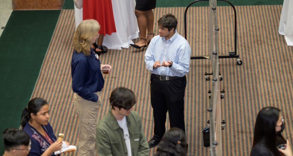 Attendees speak at a poster session