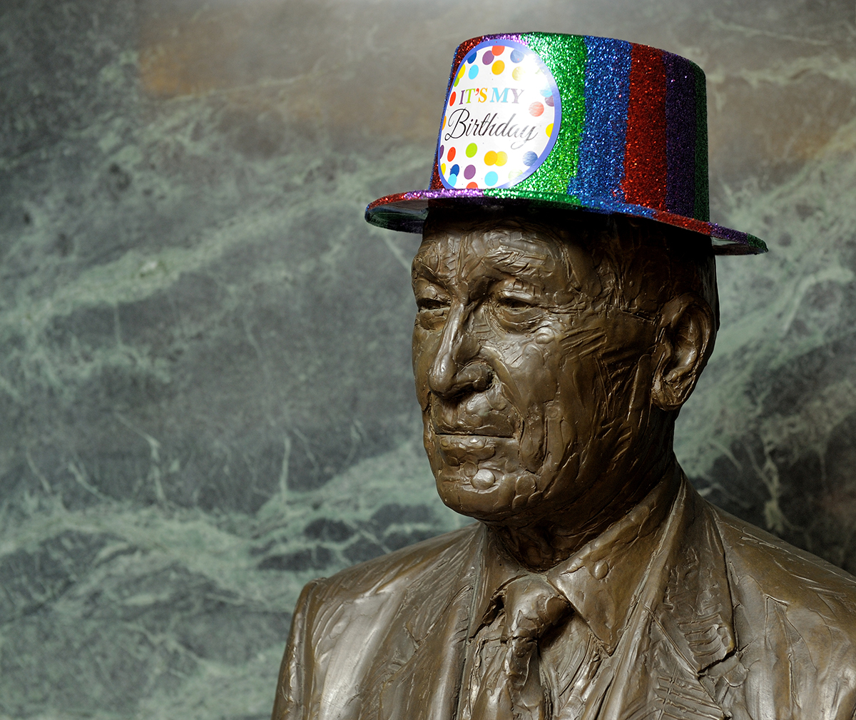 In honor of events planned around Arnold Beckman's birthday on April 10, hissculpture (statue) at the Beckman Institute wears a green, blue, red top hat with "It's My Birthday" on the front.