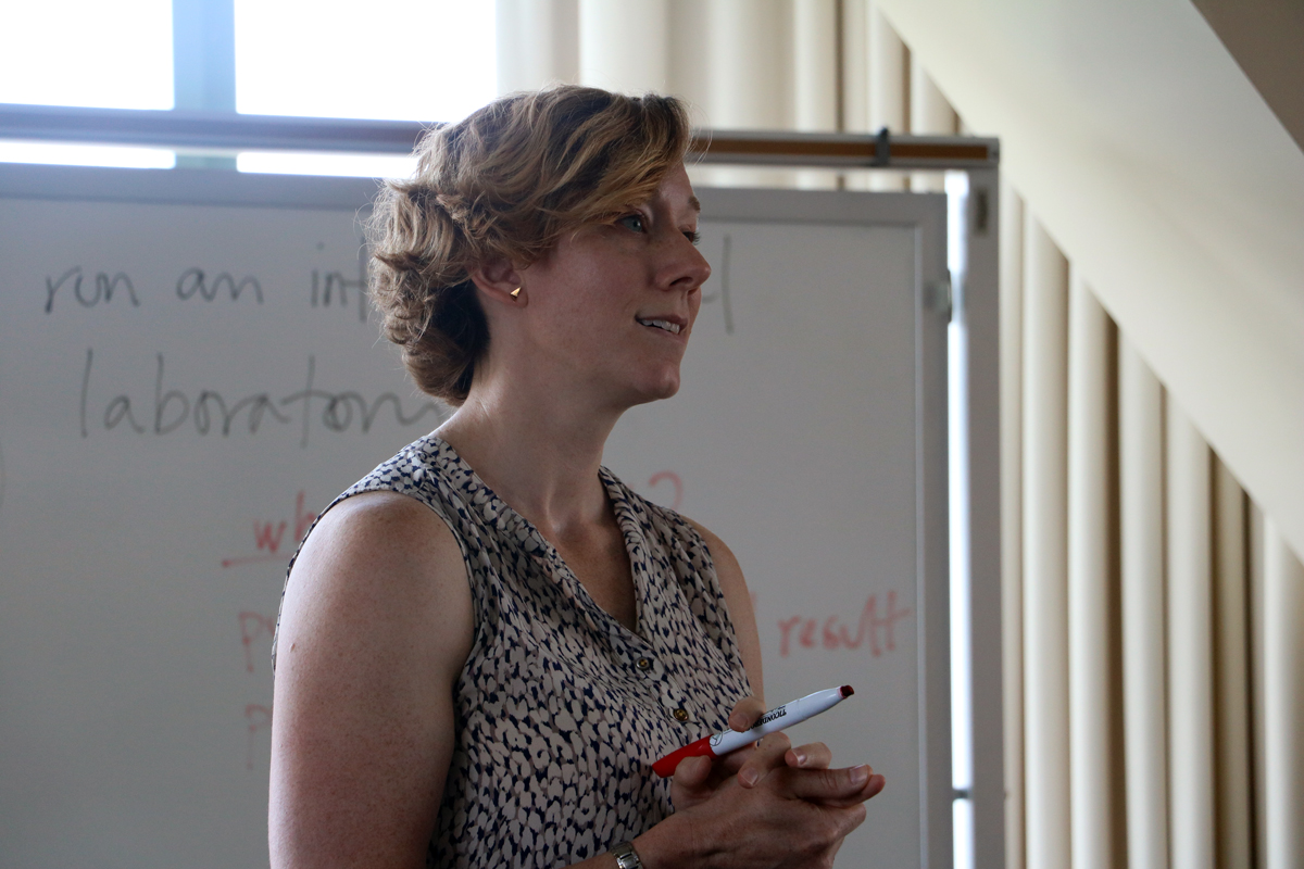 Kate Clancy speaks at a lecture in one of Beckman's Tower Rooms with a white board behind her.