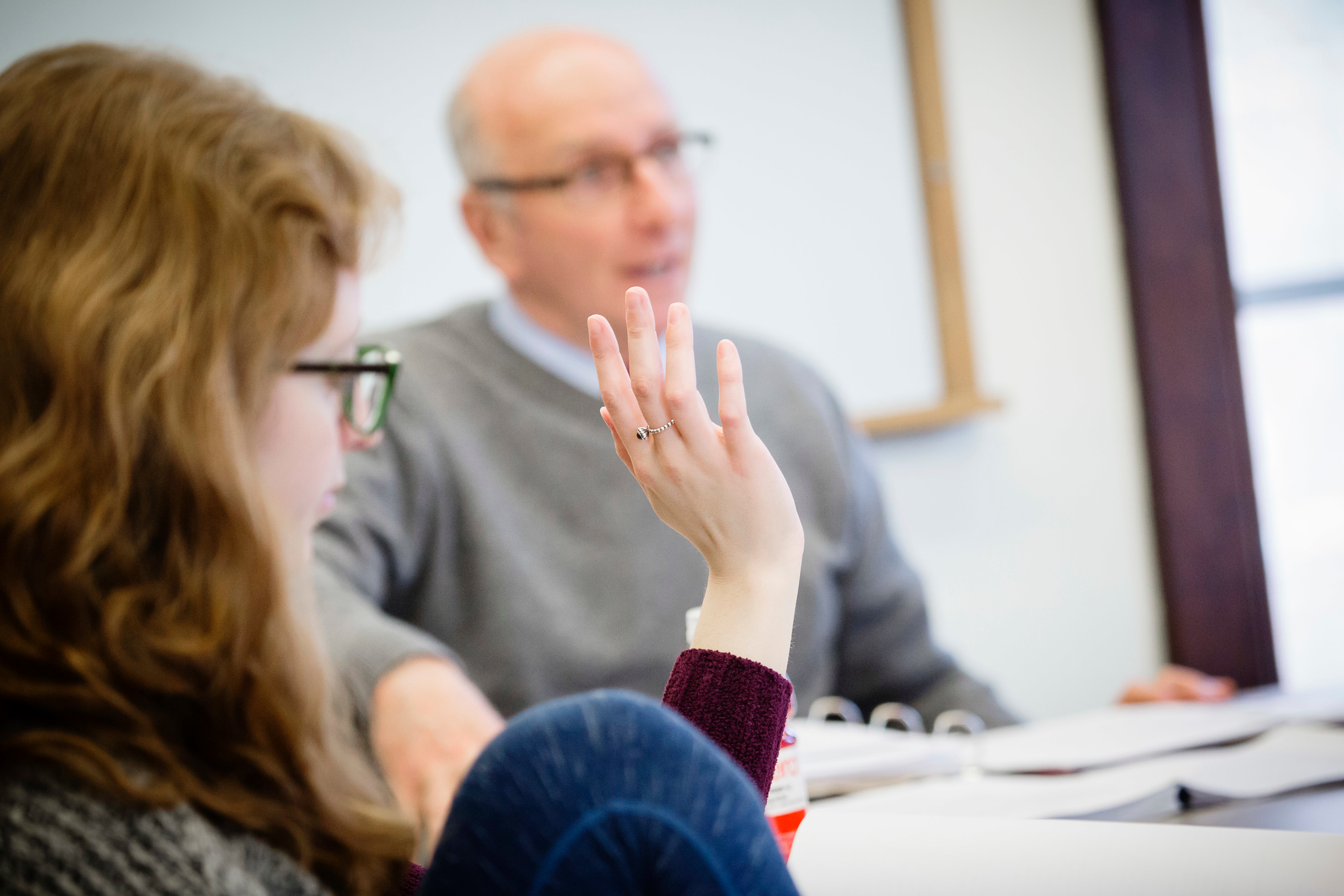 A student raises a hand during a class at the Campus Honors Program.