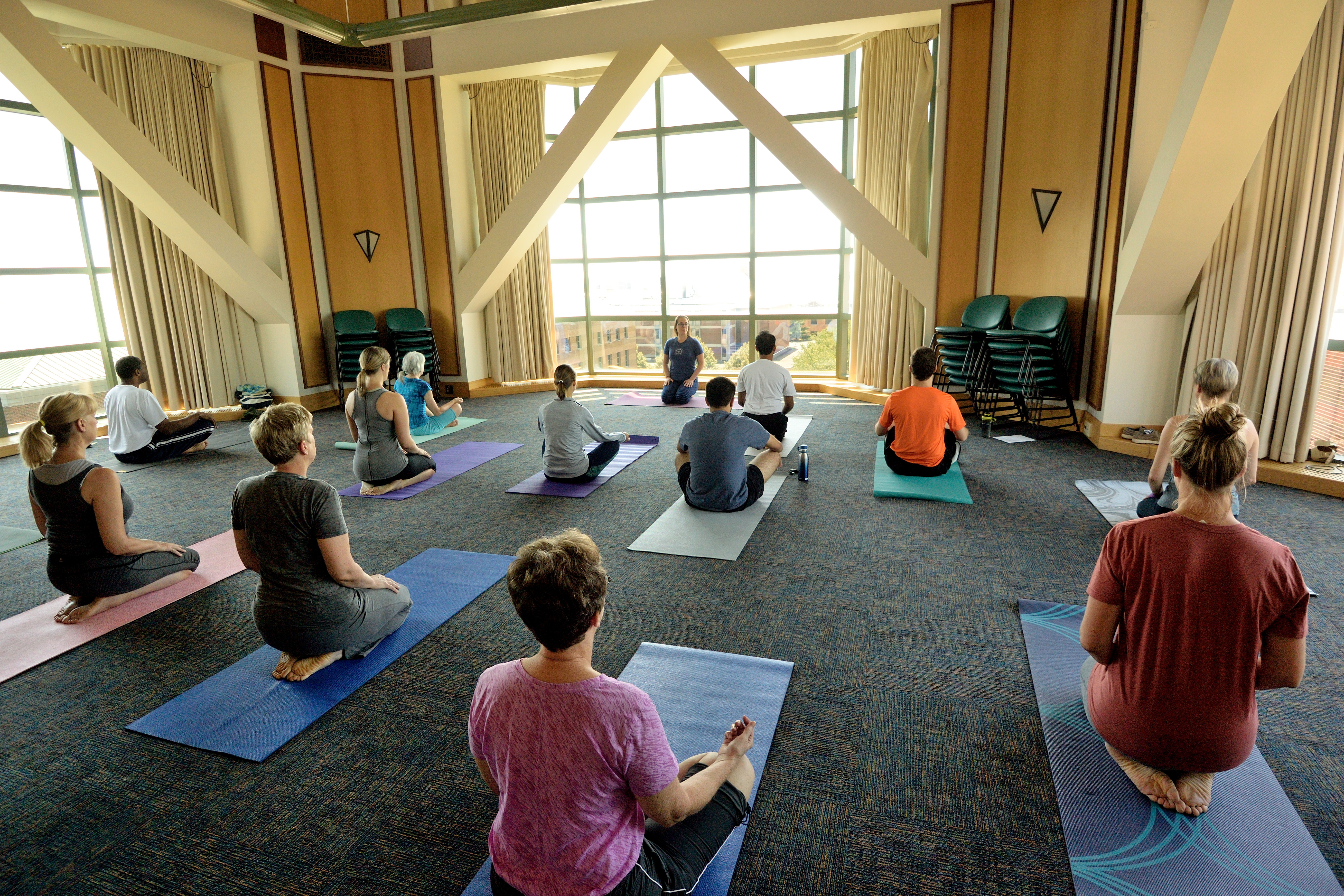 A group of people doing yoga in the fifth-floor Tower Room at the Beckman Institute
