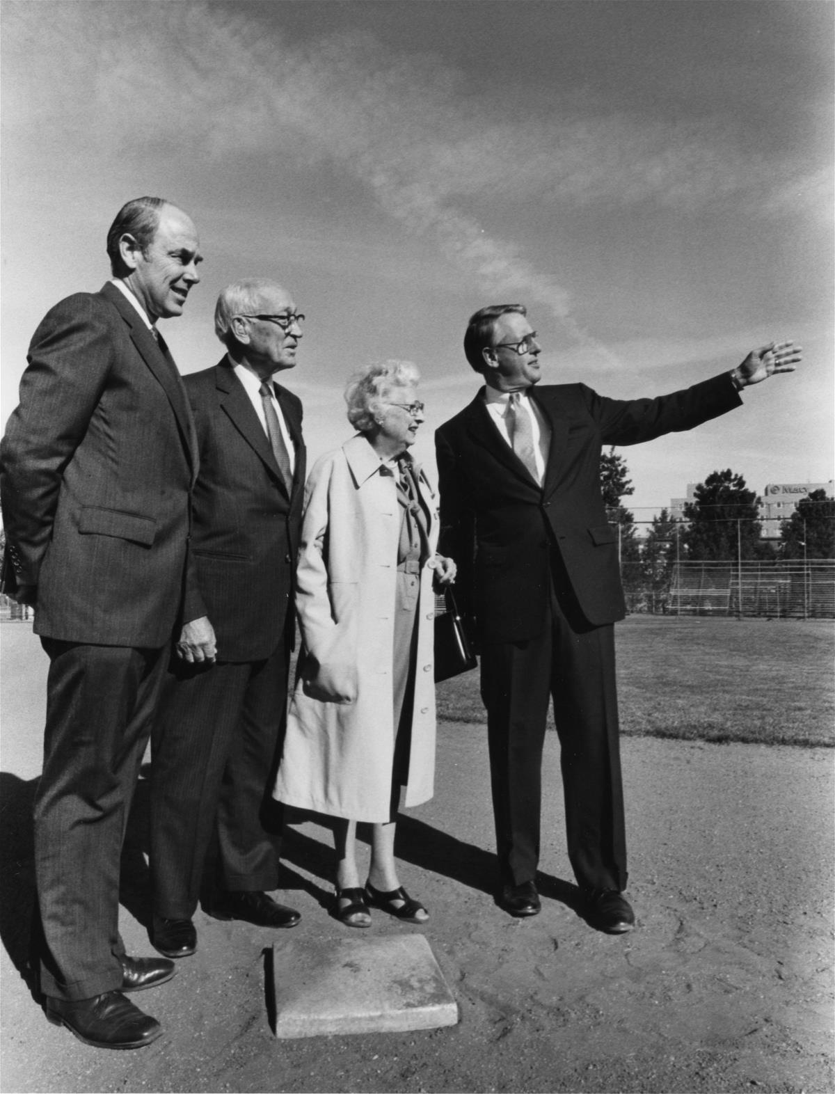 Arnold and Mabel Beckman stand with President Stan Ikenberry and another identified man on a base on Illinois Field. The field later became home to the Beckman Institute.