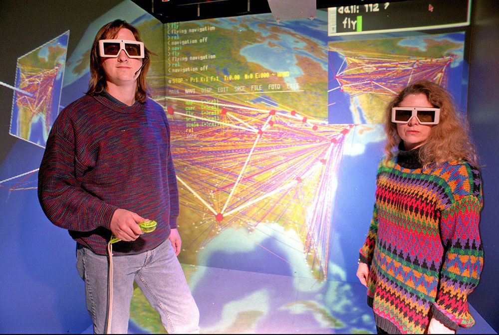 Researcher wearing dark glasses stand in front of a simulation screen.