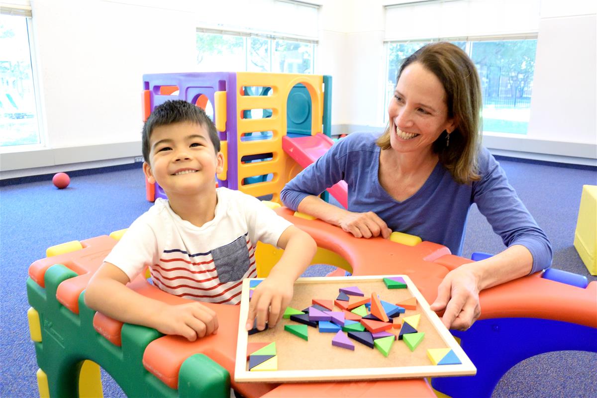 Nancy McElwain at ECDL with child doing puzzle