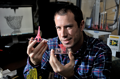 Researcher Matt Gelber shows small lacy 3D-printed objects, including an Eiffel Tower replica.