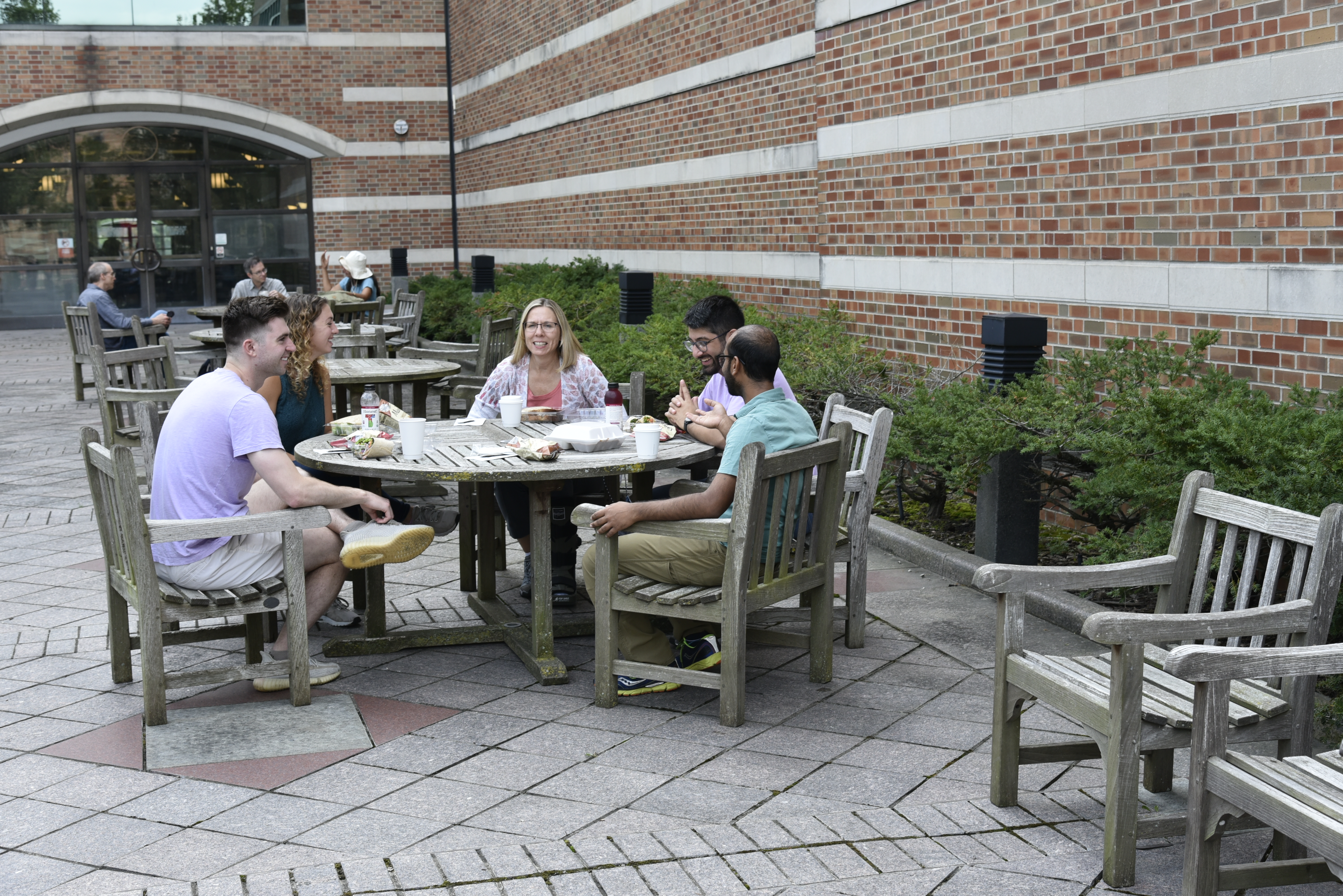 A group of researchers, including Nancy Sottos, enjoy a talkative, lively lunch in Beckman's garden.