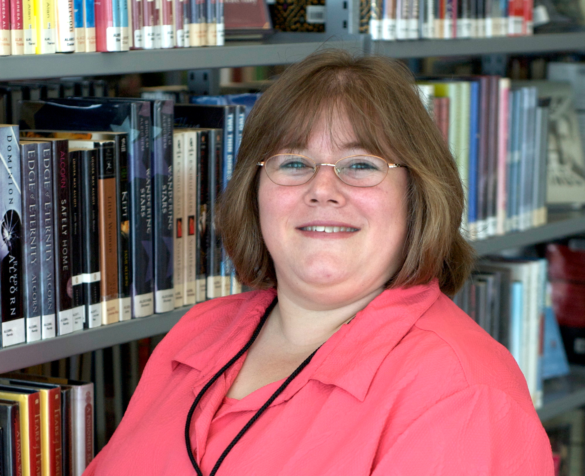 Kristina Hoerner in front of a bookshelf lined with books.