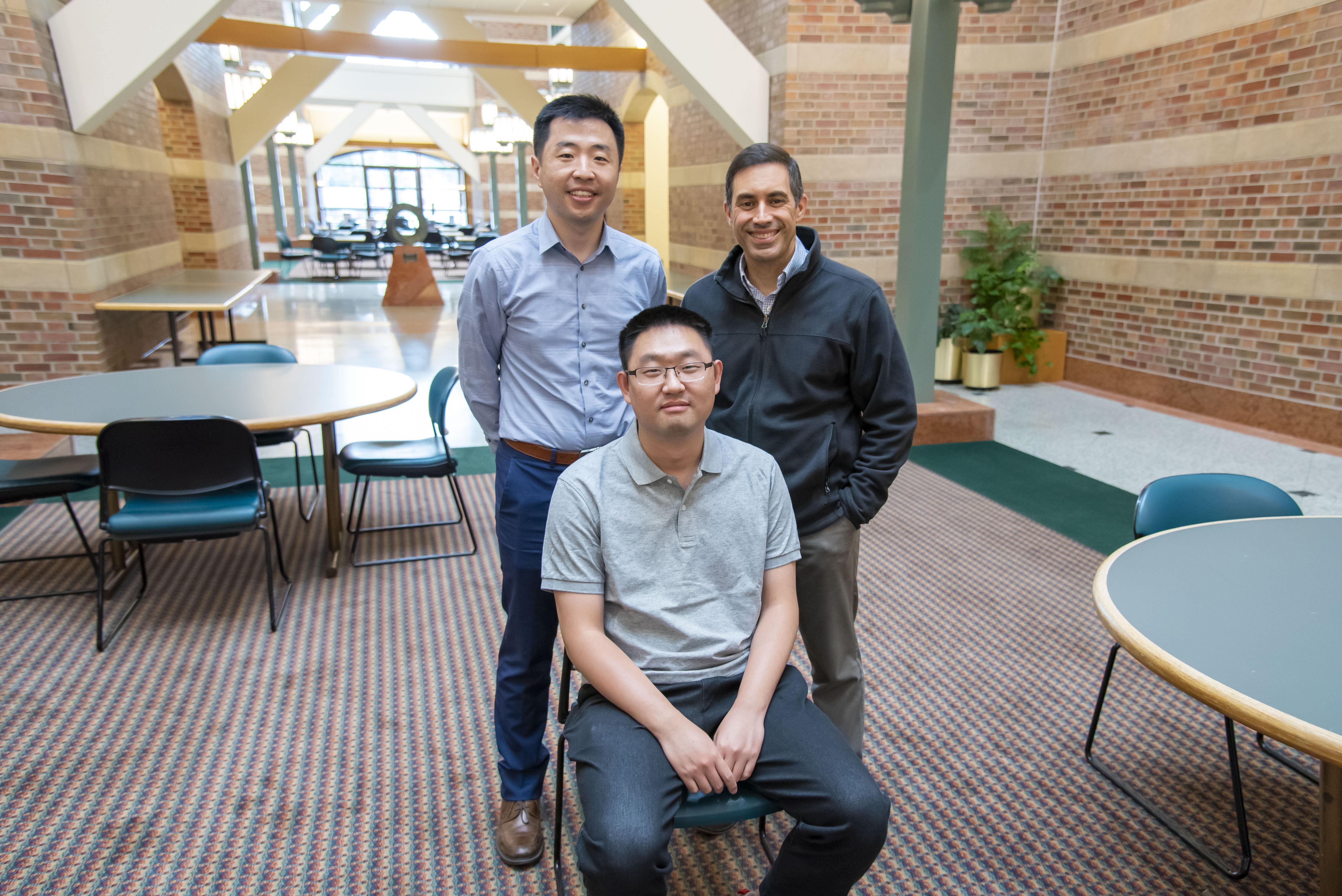 Pengfei Song, Dan Llano, and Qi You in the Beckman Atrium.