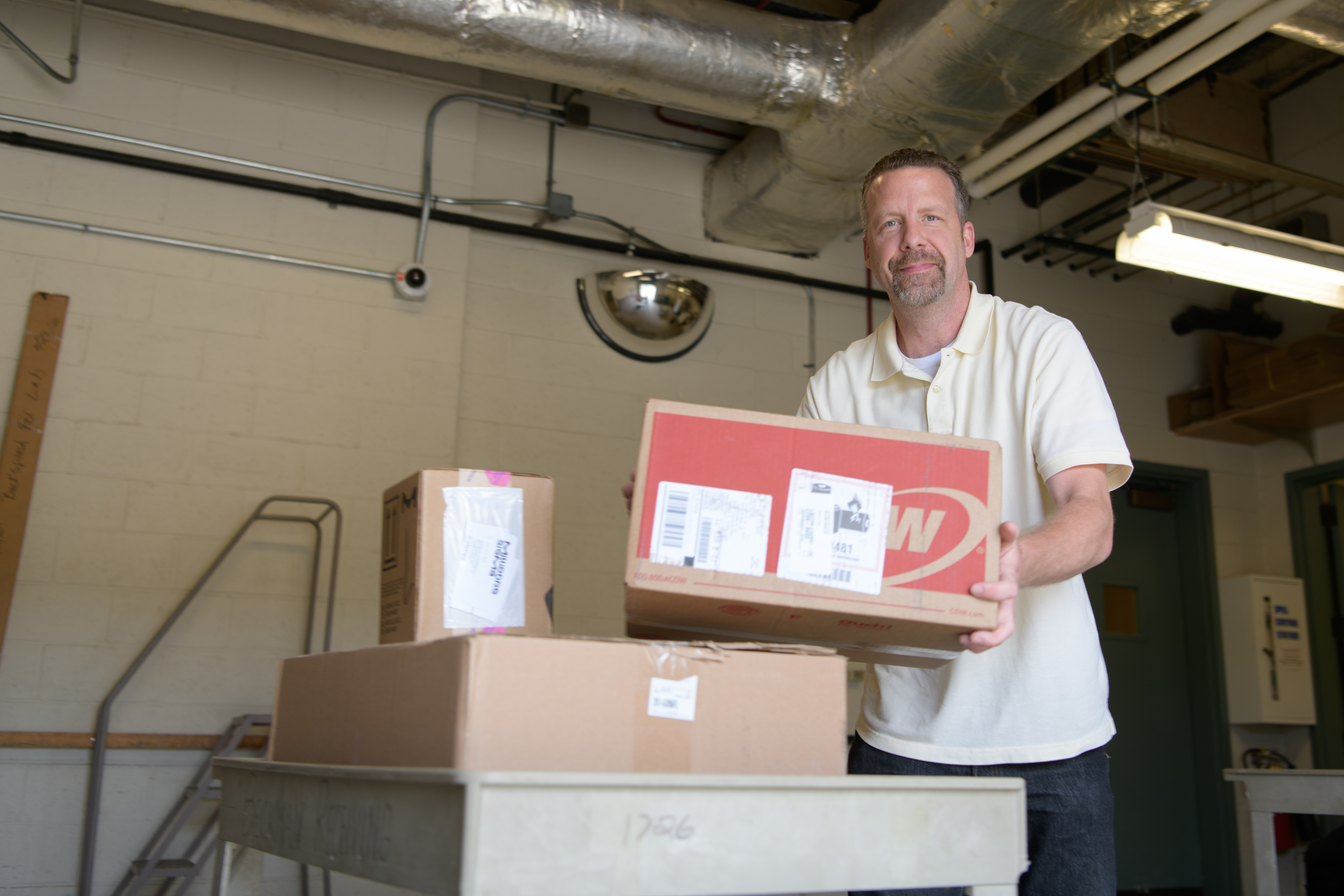 Ryan Wilson, the Beckman Institute's facility operations specialist, holds a box ready to be shipped.