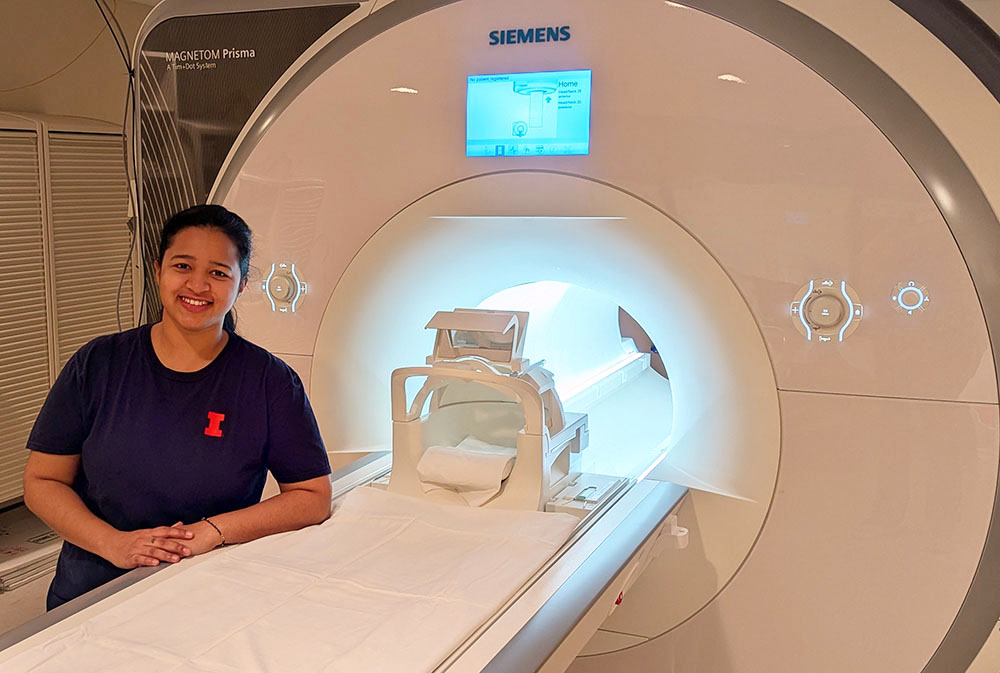 Shagun Ajmera in front of an MRI scanner