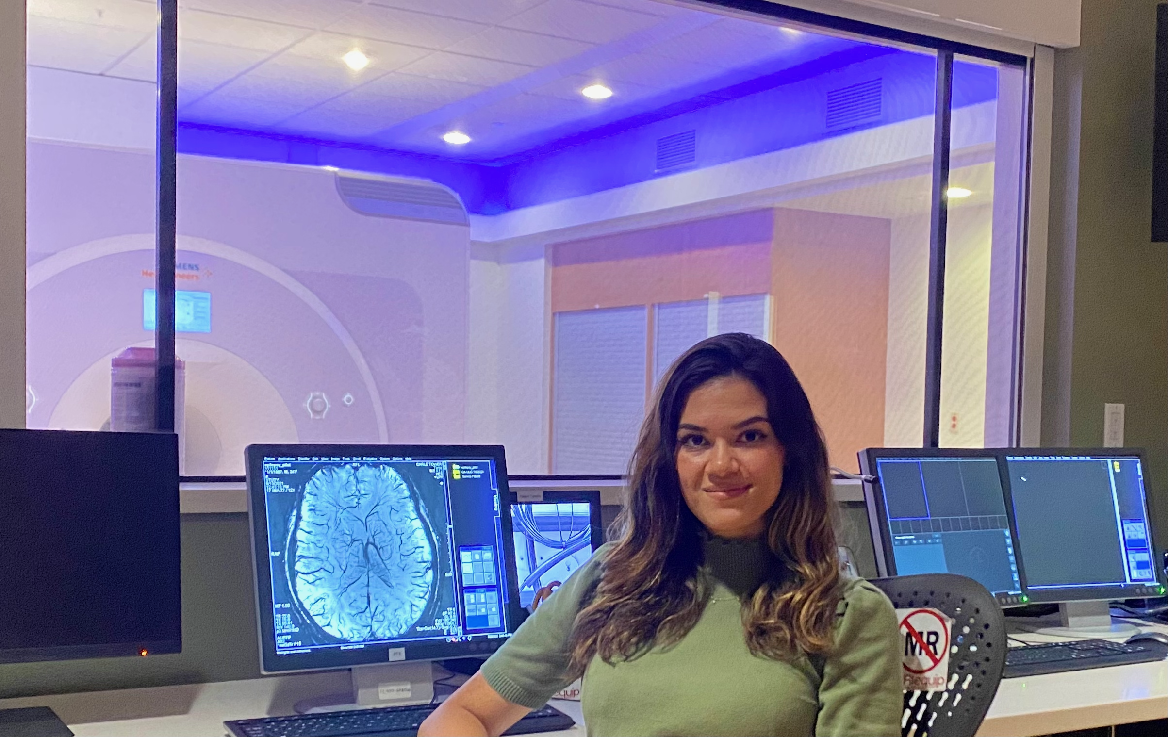 Liz Spurlock sits in front of an MRI scanner