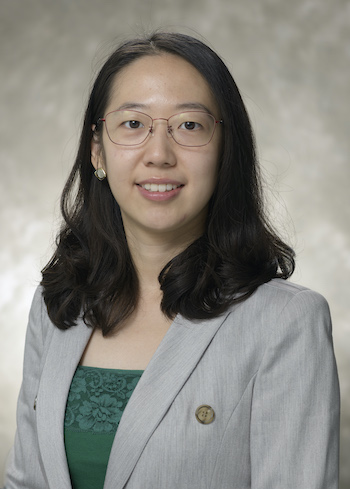 Yannan Hu, a smiling woman with glasses and shoulder-length black hair wearing a gray blazer.