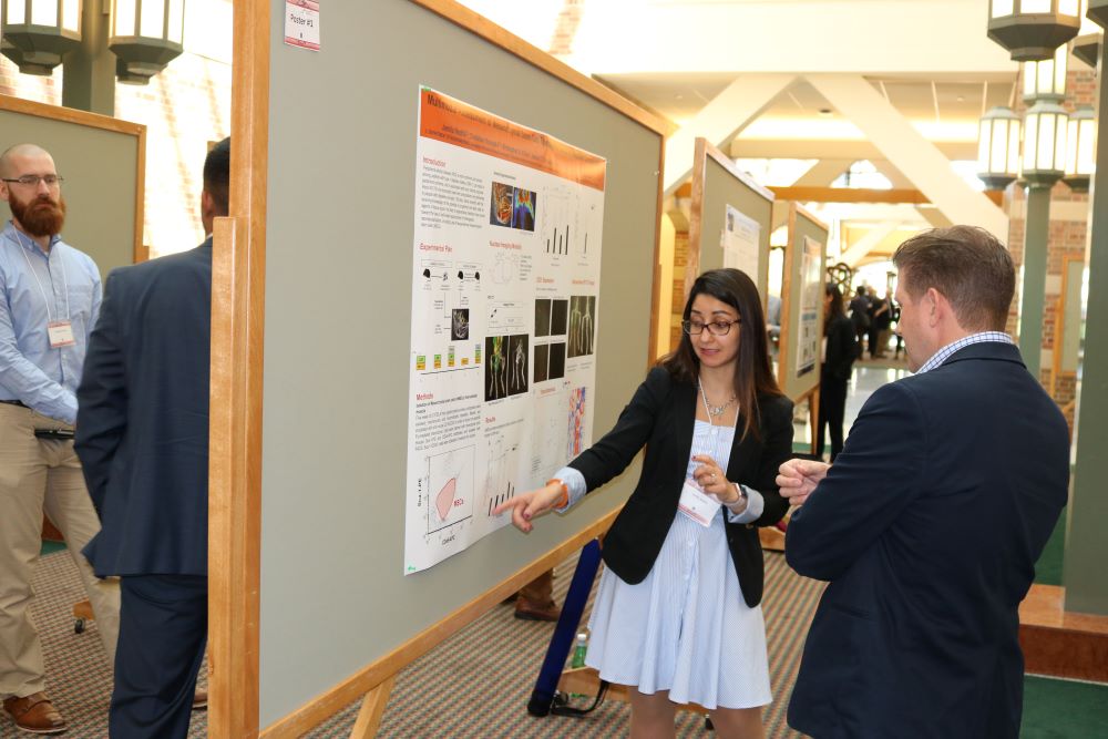 Student presents her poster to a faculty member