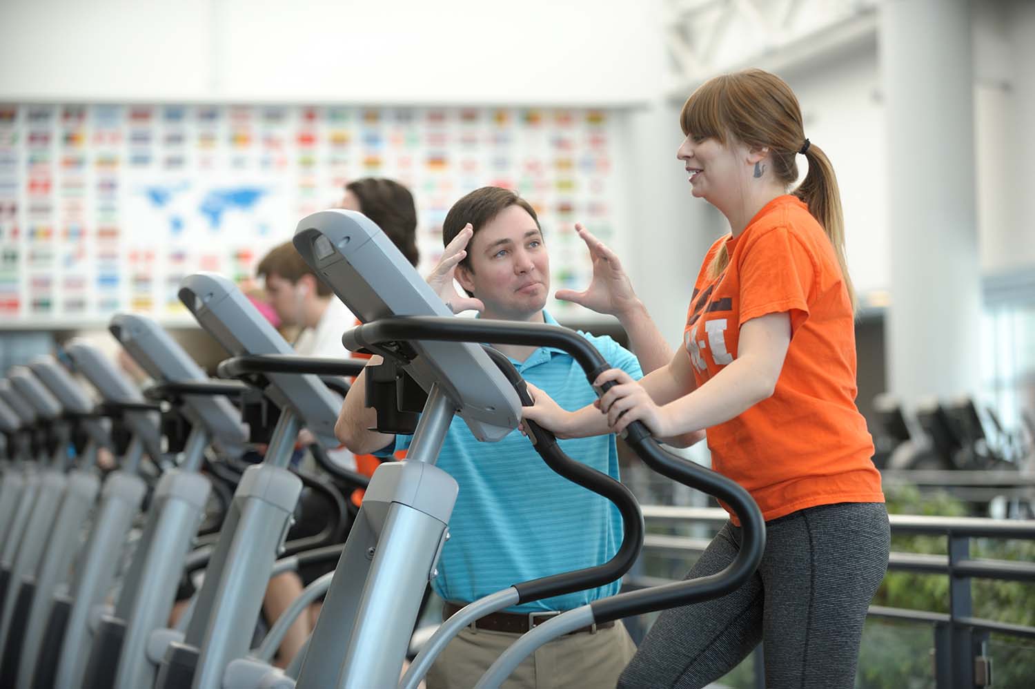 A researcher talks to a subject on a treadmill